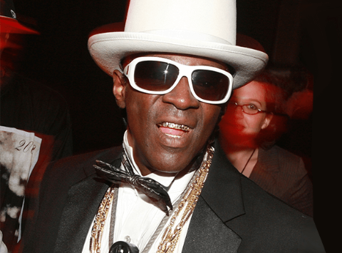 Flavor Flav poses a picture at an event.